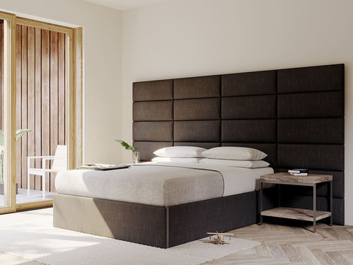 Modern bedroom with a large upholstered vantpanel headboard, wooden sliding door, and minimalistic decor.