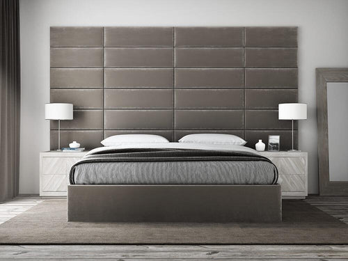 A modern bedroom featuring vantpanel Panels behind a large padded headboard, matching bedside tables, and white lamps.