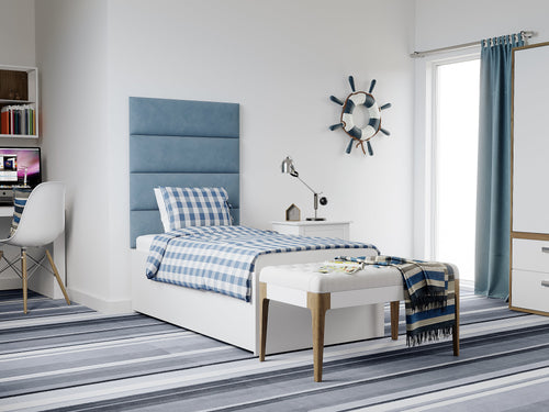 A tidy, nautical-themed bedroom with a blue and white color scheme, featuring a striped rug, a ship's wheel on the wall, and a bed adorned with vantpanel panels for an updated look.